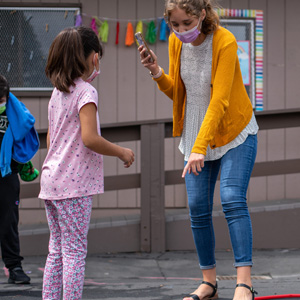 Woman and children outside of classroom.