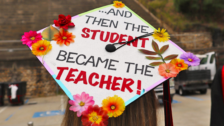 A graduation cap decorated with the words "And then the student became the teacher."