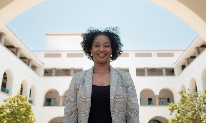 A smiling Kimberley Folkes-Dunkley on the steps of the Conrad Prebys Aztec Student Union.