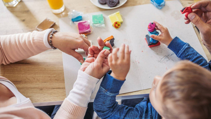 child and parent playing with modeling clay